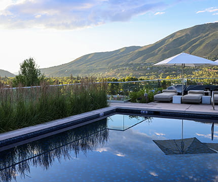 The rooftop pool at The Residences at The Little Nell in the summer during sunset.
