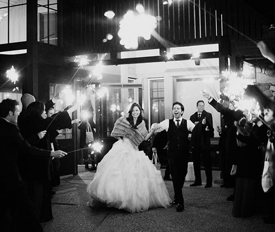 A bride and groom making a grand exit from their Aspen wedding at the Sundeck at The Little Nell.