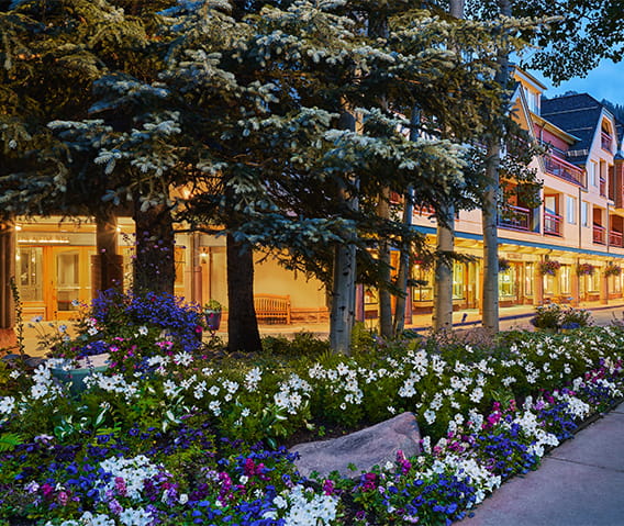 The Little Nell Hotel exterior with flower beds in front of the entrance. 