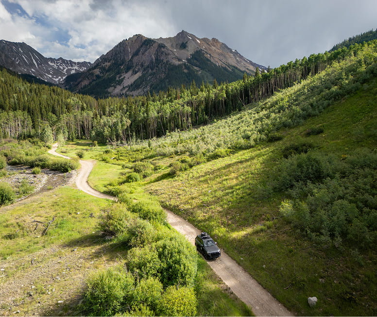 audi car driving on road in front of mountains