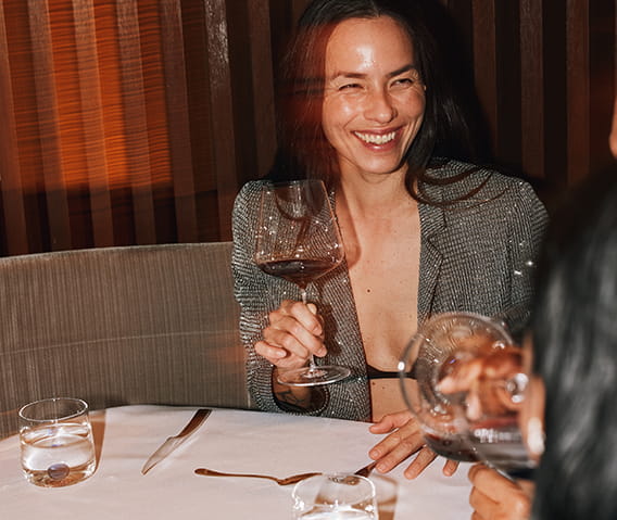 woman smiling and drinking wine at restaurant