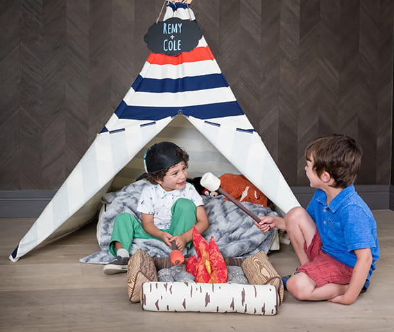 Two children playing with a Little Nell children's tepee amenity.