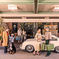A vintage style photograph by Gray Malin depicting guests outside the front door of The Little Nell.