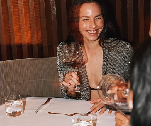 woman laughing and drinking wine