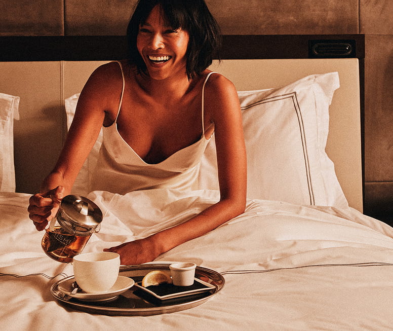 woman on bed eating breakfast