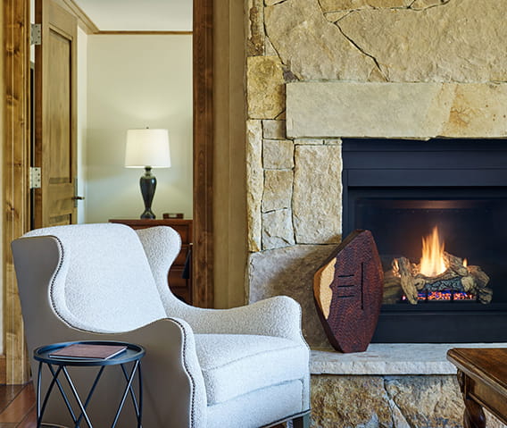 A chair next to a cozy fireplace in a luxury Aspen hotel.