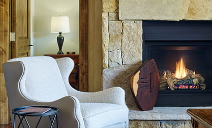 A chair next to a cozy fireplace in a luxury Aspen hotel.