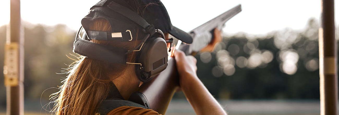 A woman clay shooting.