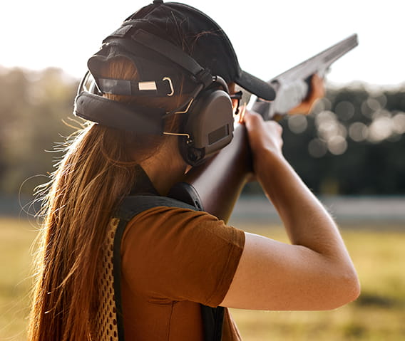 A woman clay shooting.