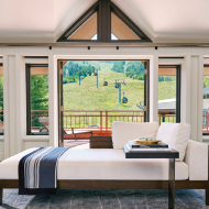 A luxurious lounge area and balcony with mountain views in one of The Little Nell's suites.