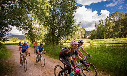 Six guests of The Little Nell enjoy a bike ride through scenic Aspen in the summer. 