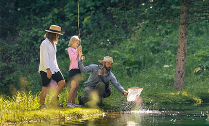 Woman and child catching fish with fly fishing guide