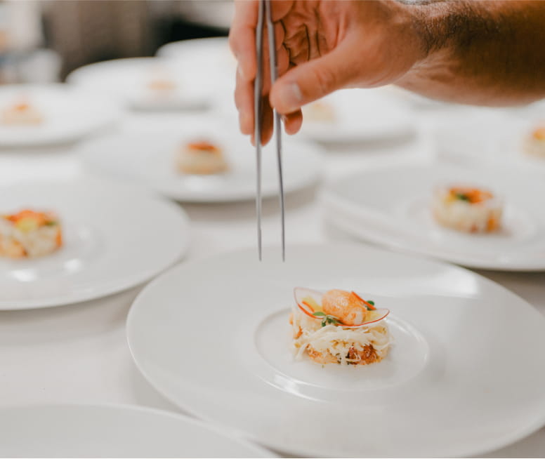 person plating food on dish