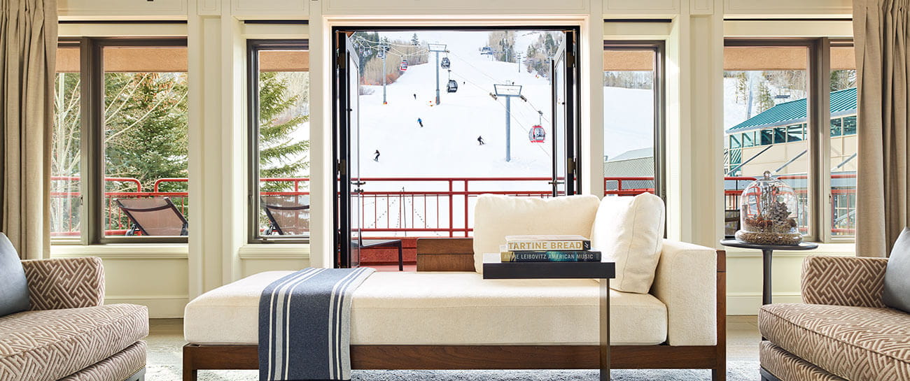 A luxury suite's panoramic window shows views of Aspen Mountain.