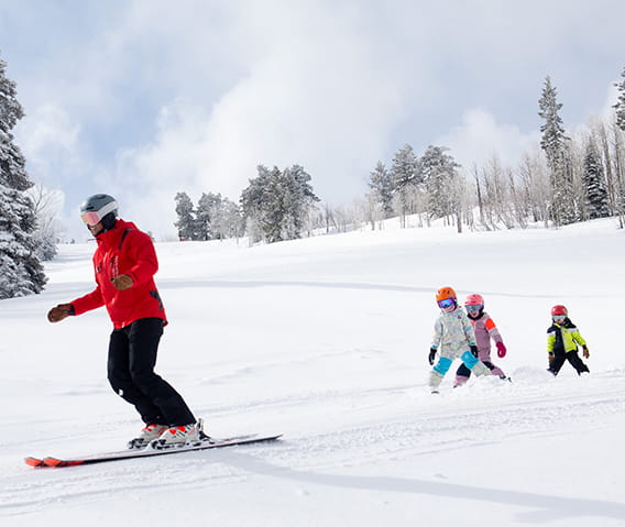 Children and an instructor skiing during ski school.