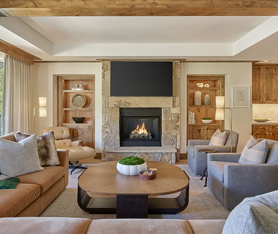 The living room of a Residence at The Little Nell with cozy seating arrangements and fireplace. 
