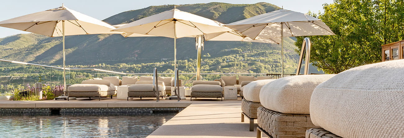 The rooftop pool at the Residences at The Little Nell provides stunning 360 degree panoramic views of Aspen and its surrounding mountains, and plush patio furniture for guests to relax and soak up the sun.