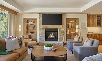 The living room of a Residence at The Little Nell with cozy seating arrangements and fireplace. 