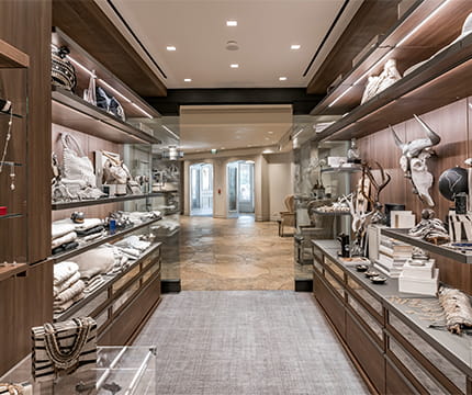 The inside of the boutique at The Little Nell with novel items on the shelves and the lobby through the doorway.