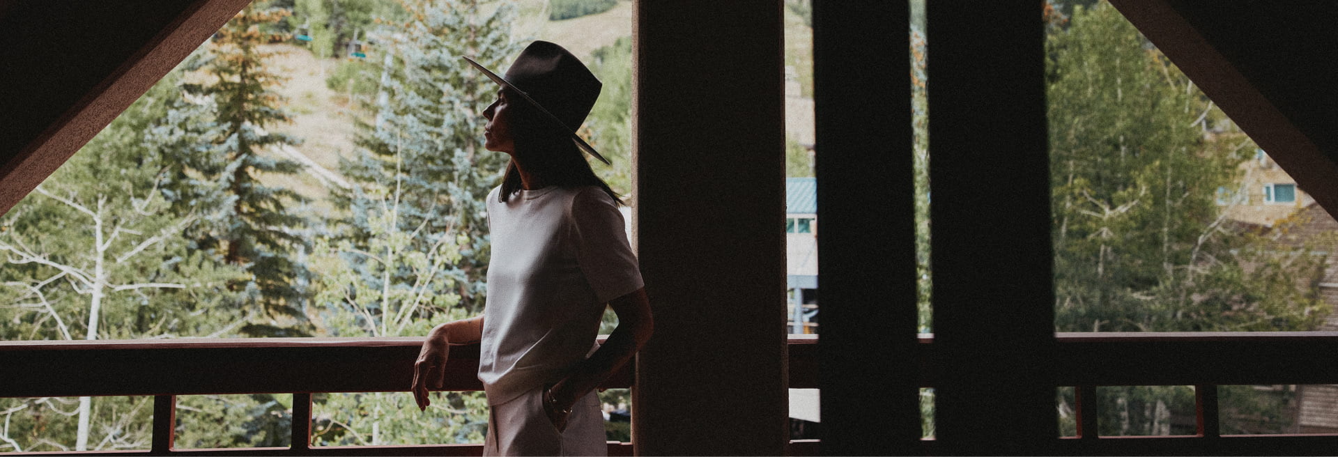 woman on balcony looking at trees