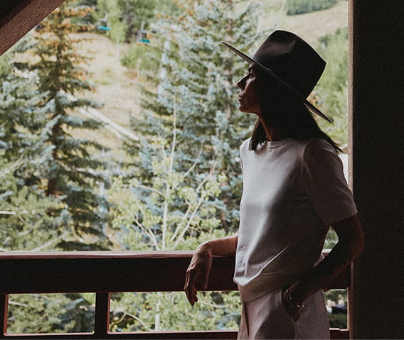 woman on balcony looking at trees
