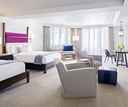 Spacious double queen room with desk, TV, and fireplace.