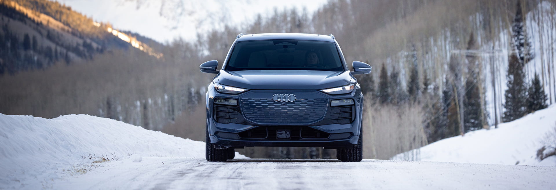 audi car driving on road in front of mountains