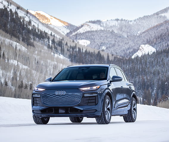audi car driving on road in front of mountains