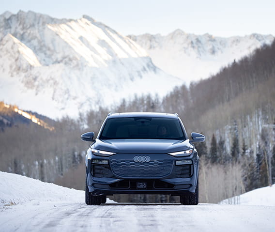 audi car driving on road in front of mountains