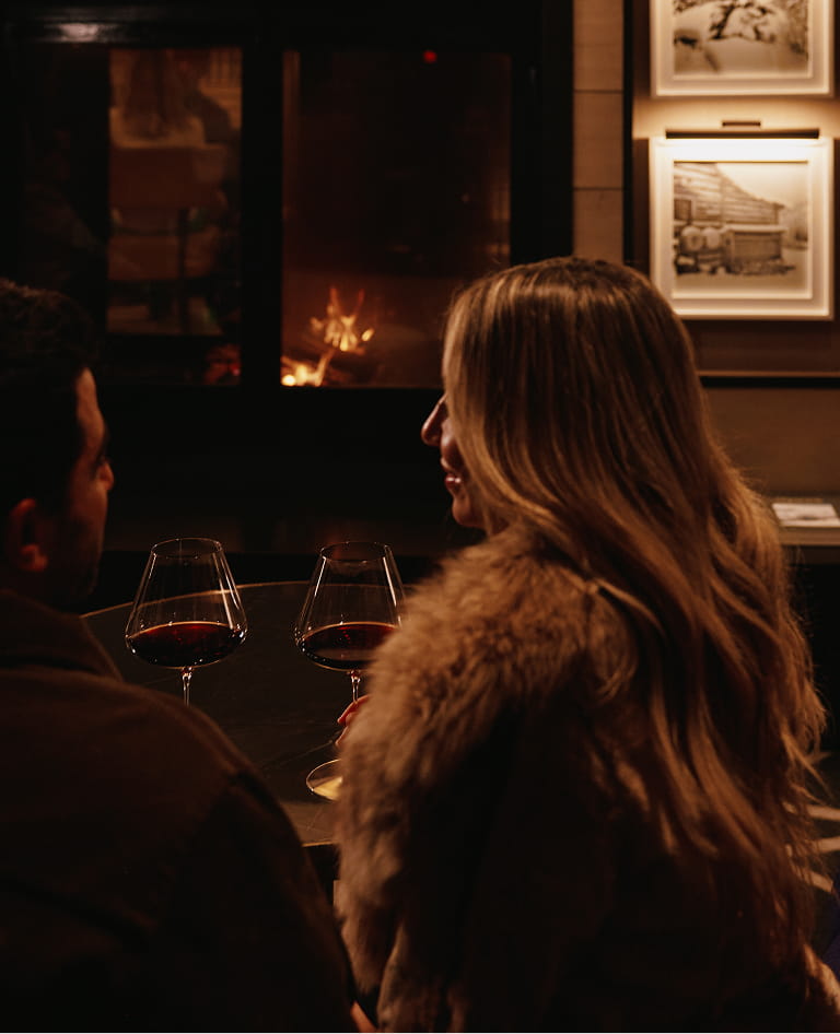 couple having wine by fireplace