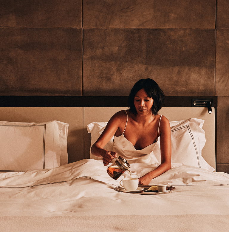 woman on bed eating breakfast