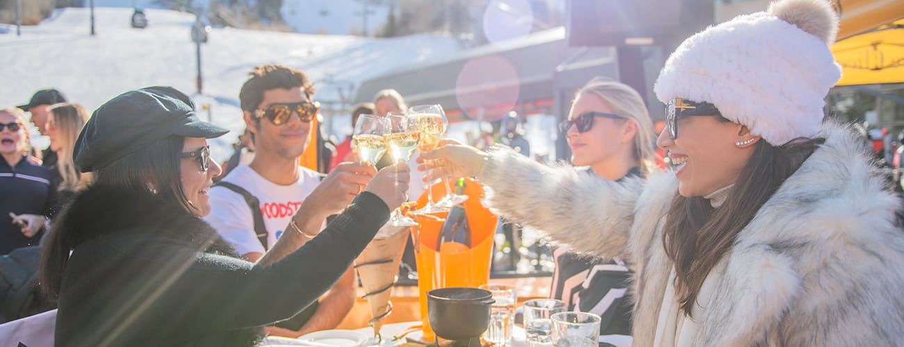 friends toasting champagne outside at ajax for apres ski on a sunny spring day