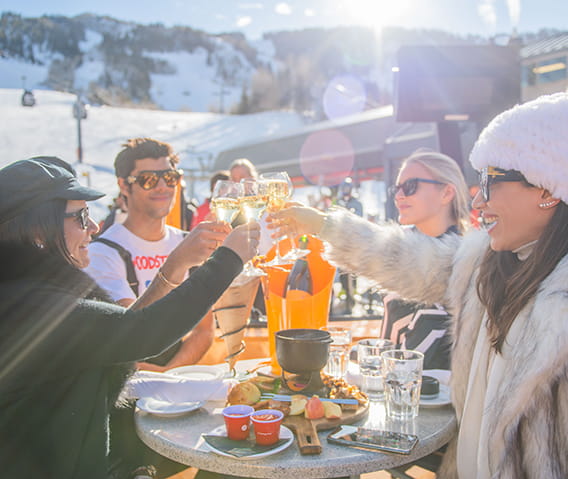friends toasting champagne outside at ajax for apres ski