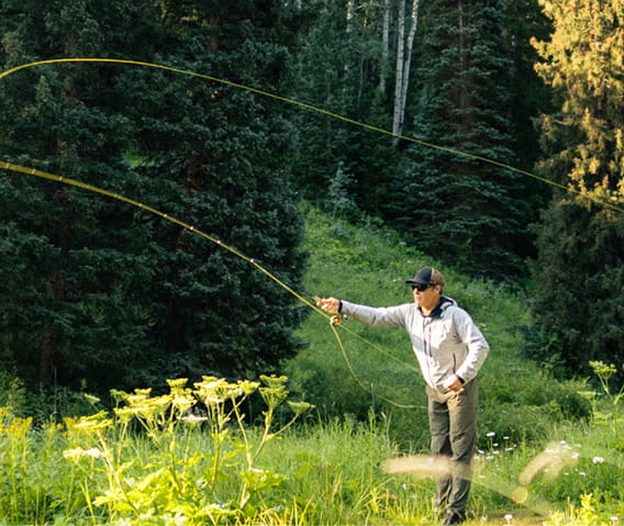 man fly fishing in the mountains