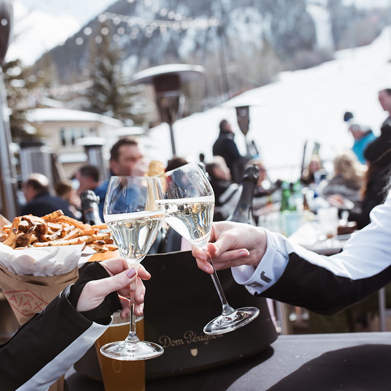 Two people cheerings champagne at ajax patio