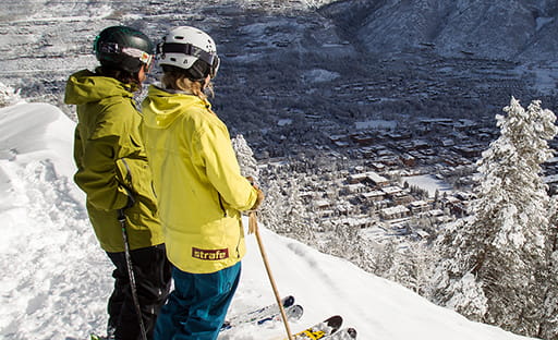 two skiers looking out over aspen mountain